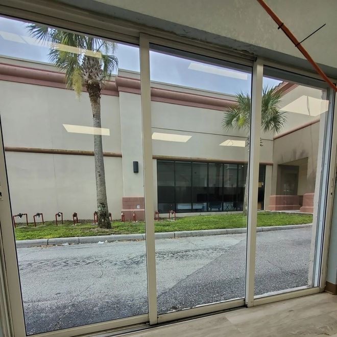 A sliding glass door with a palm tree in the background