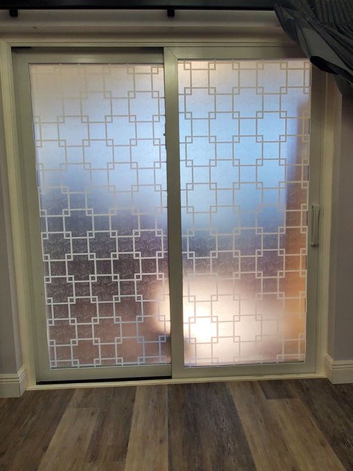 A room with a sliding glass door and a view of the ocean.