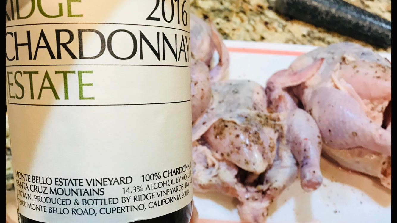 A bottle of chardonnay estate wine next to some chickens