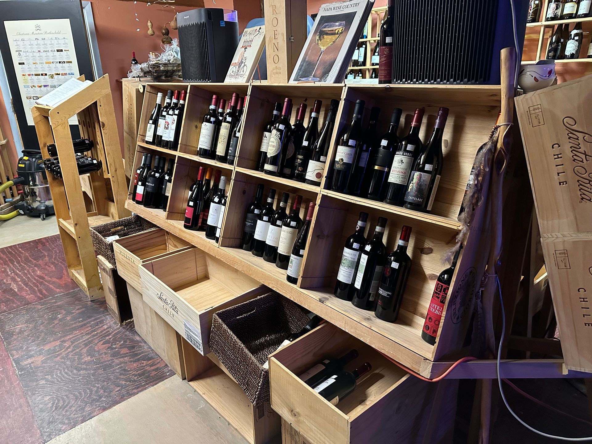 A row of wooden shelves filled with bottles of wine.