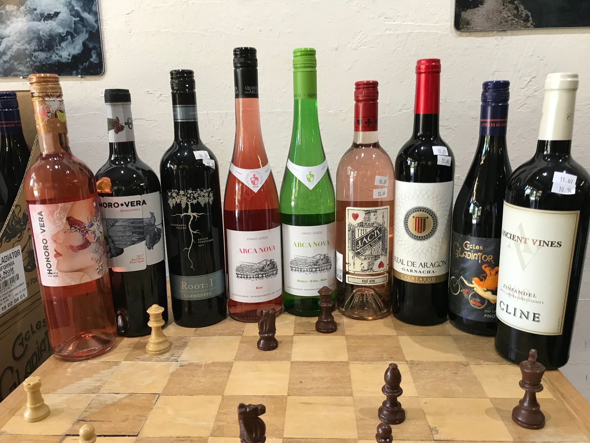 A chess board with bottles of wine and chess pieces on it.