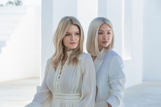 Two Blonde Women Are Standing Next To Each Other In White Dresses — Siddha Hair Studio in Currajong, QLD