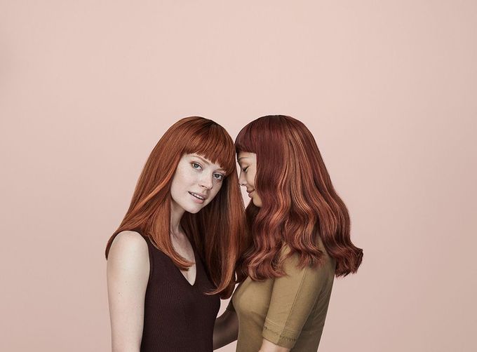 Two Women With Red Hair Are Standing Next To Each Other — Siddha Hair Studio in Currajong, QLD