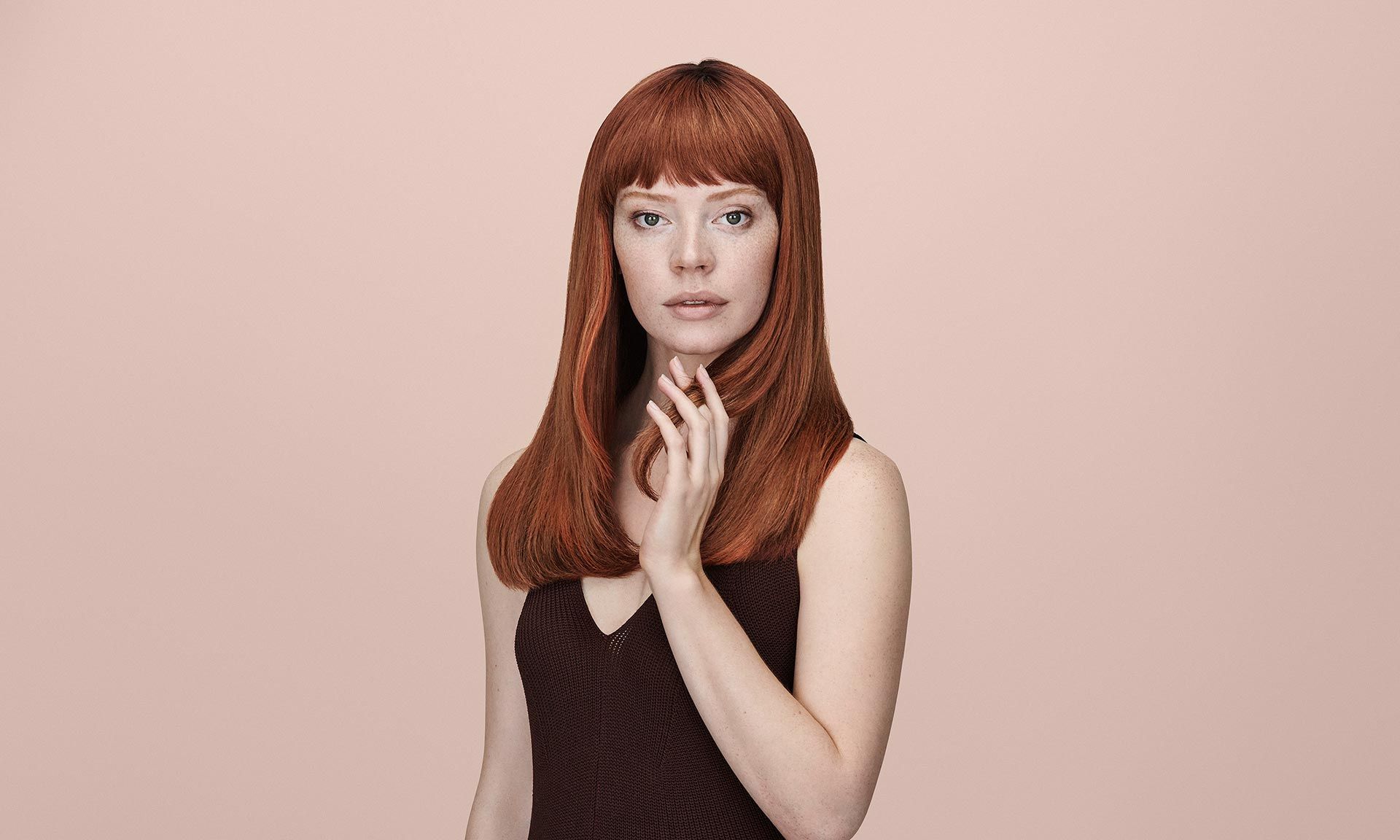 Woman With Long Red Hair Is Standing In Front Of A Pink Background — Siddha Hair Studio in Currajong, QLD