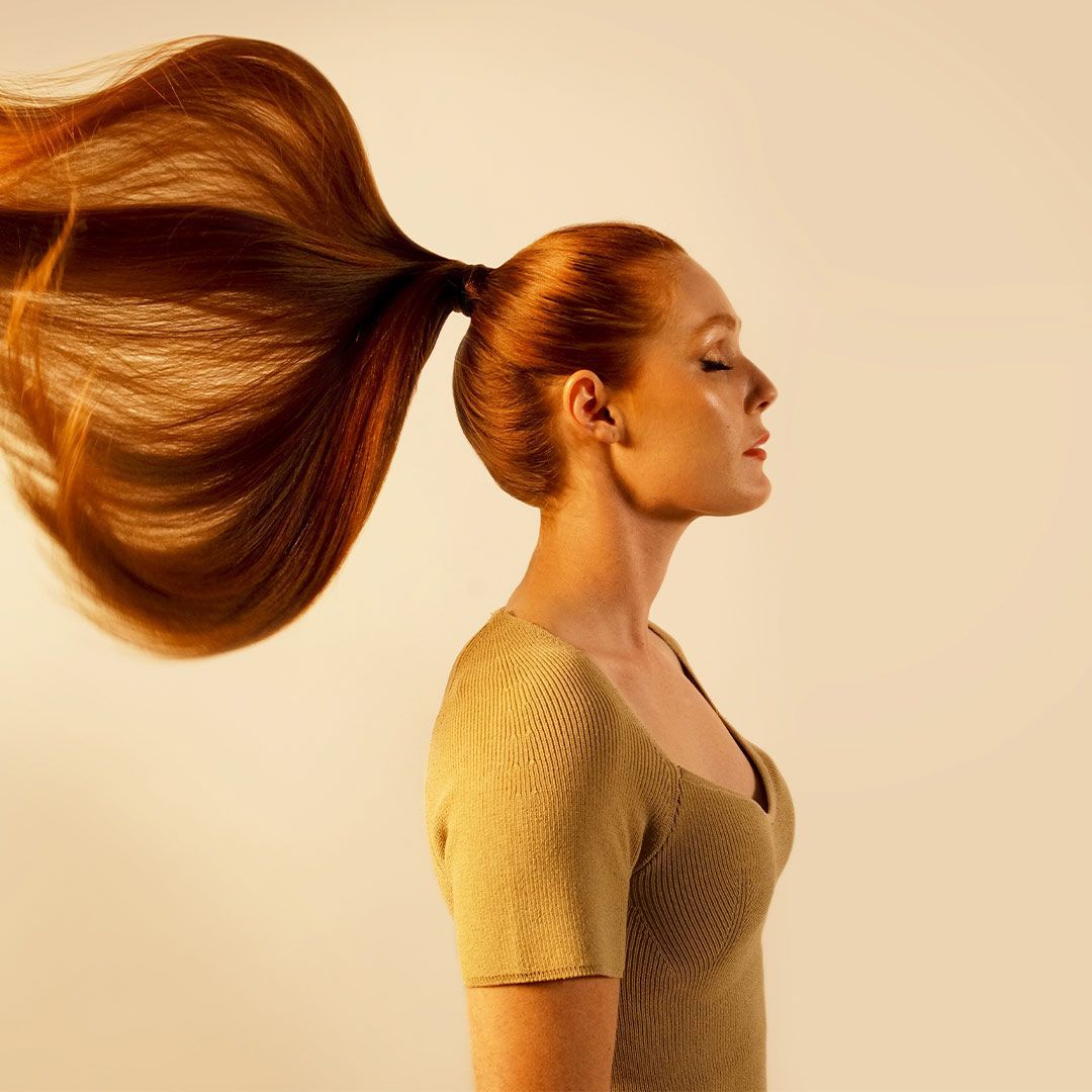 Woman With Long Red Hair In A Ponytail — Siddha Hair Studio in Currajong, QLD