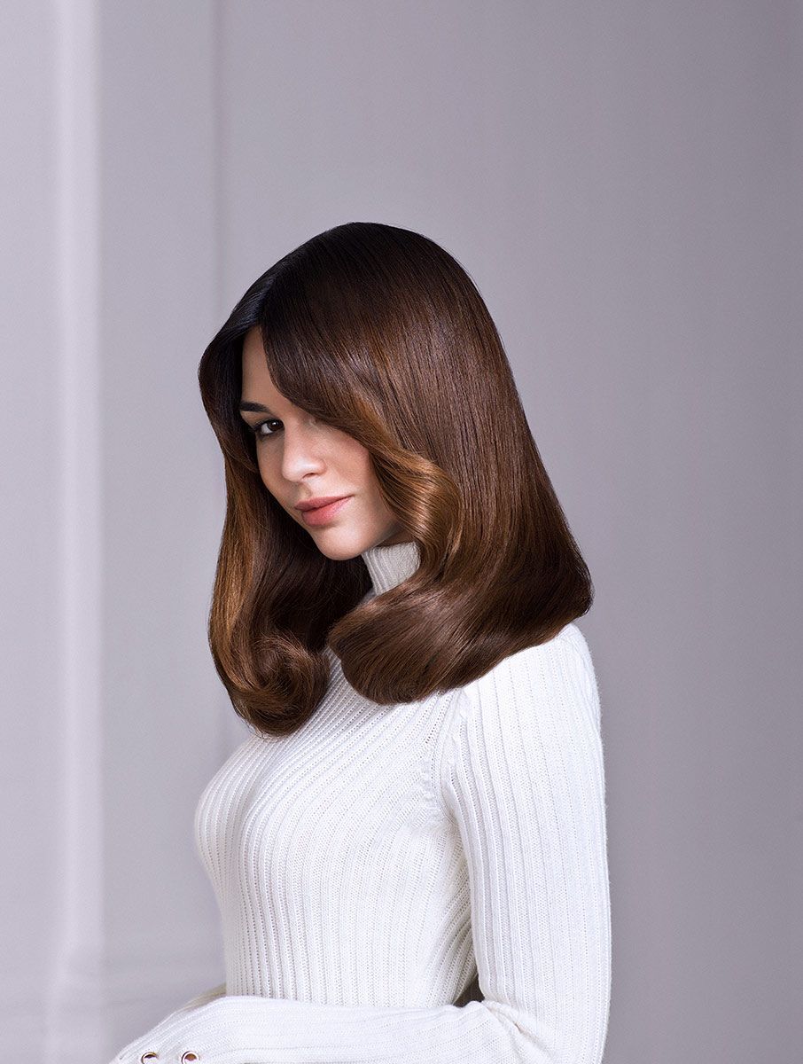 Woman With Long Brunette Hair Is Wearing A White Sweater — Siddha Hair Studio in Currajong, QLD