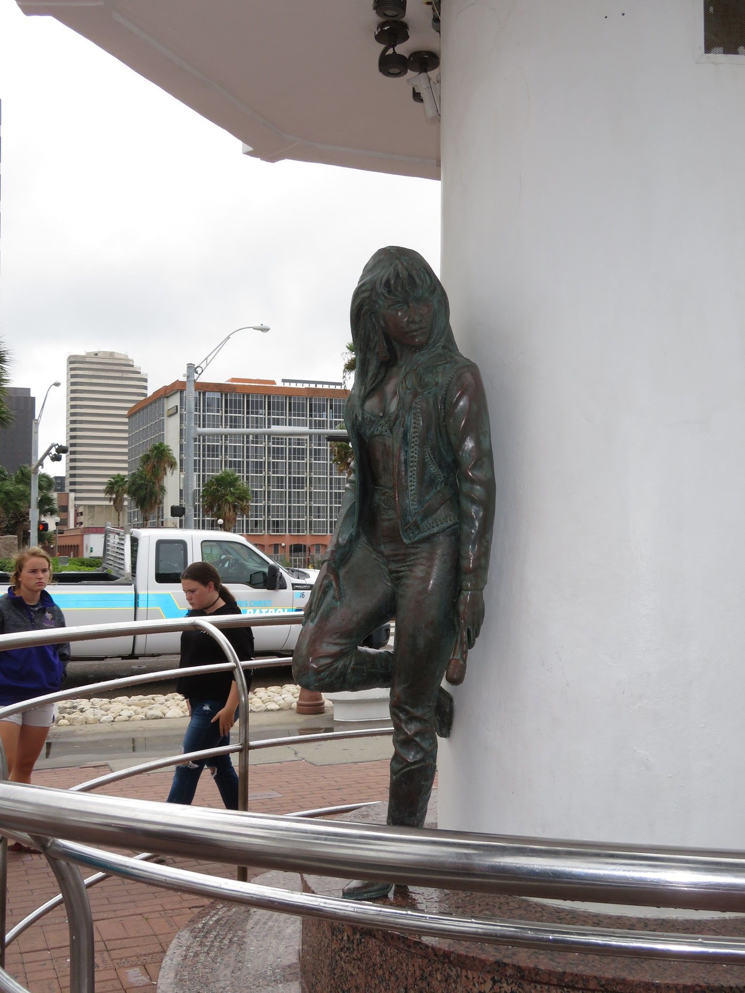 a statue of a woman leaning against a white wall