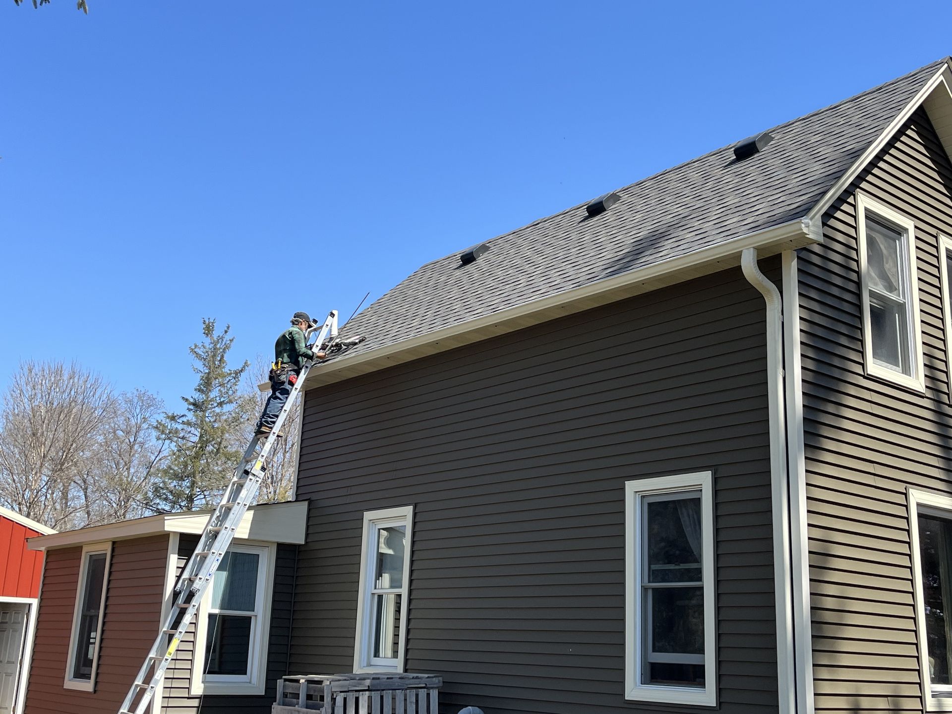 Hand With Glove Removing Autumn Leaves From Gutter - Rochester, MN - Clark's Seamless Gutters Inc
