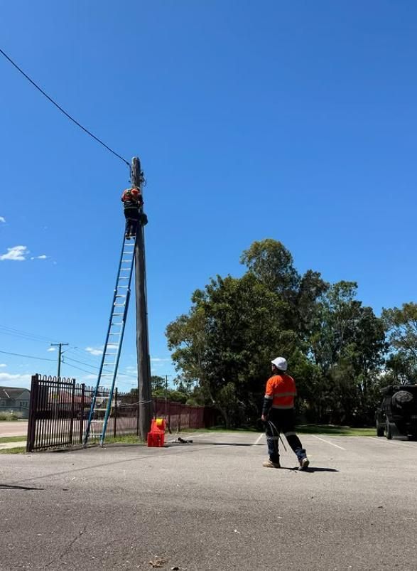 Linemen Working on a Utility Pole. One on the Pole, One on the Ground — DMP Electrical Contractors In Mandalong, NSW