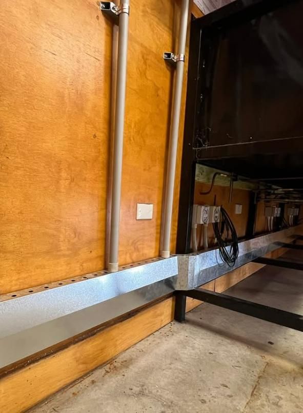 Two Pipes on Wooden Wall, Metal Trough, Electrical Outlet — DMP Electrical Contractors In Mandalong, NSW