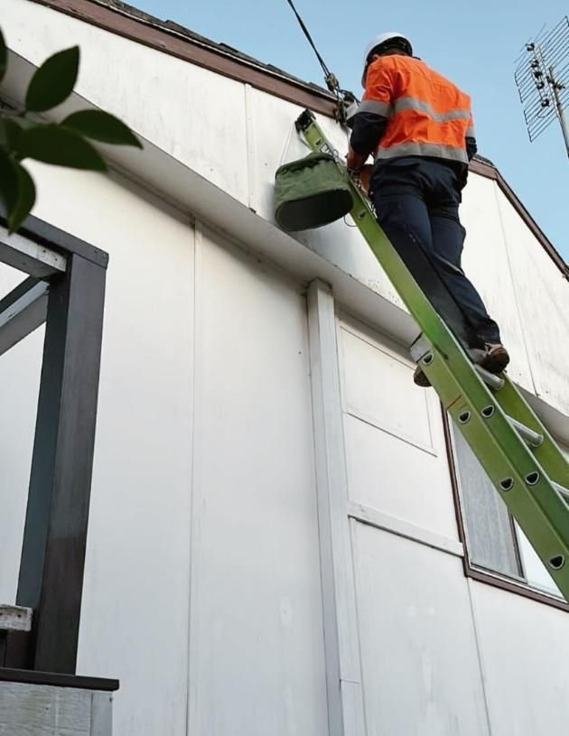 Worker on a Ladder, Cleaning Gutters — DMP Electrical Contractors In Mandalong, NSW