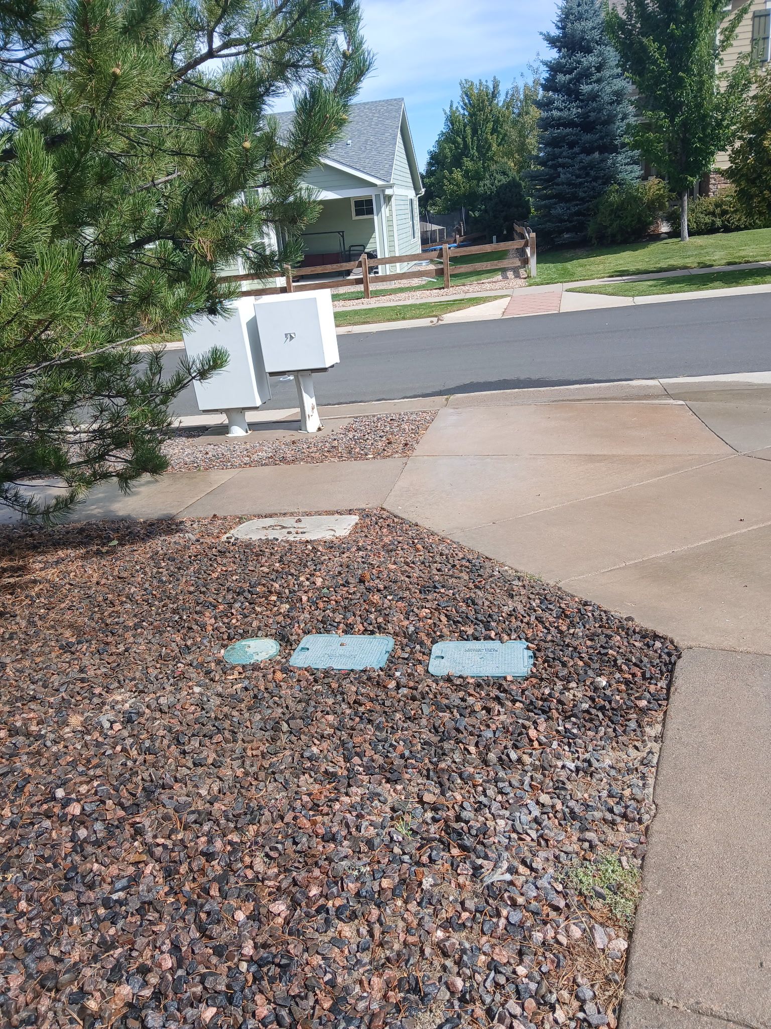 Mailboxes, path, and rock bed in front of a house.