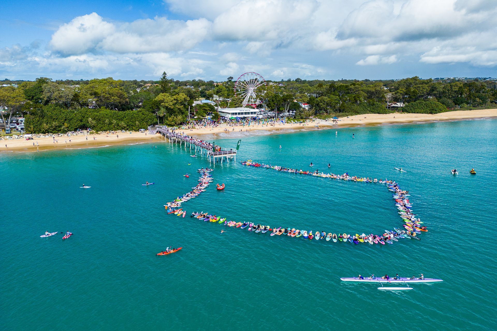 An Aerial Image Of A Beach Peer And Lots Of People In The Water — Jack West Photography In Kawungan, QLD