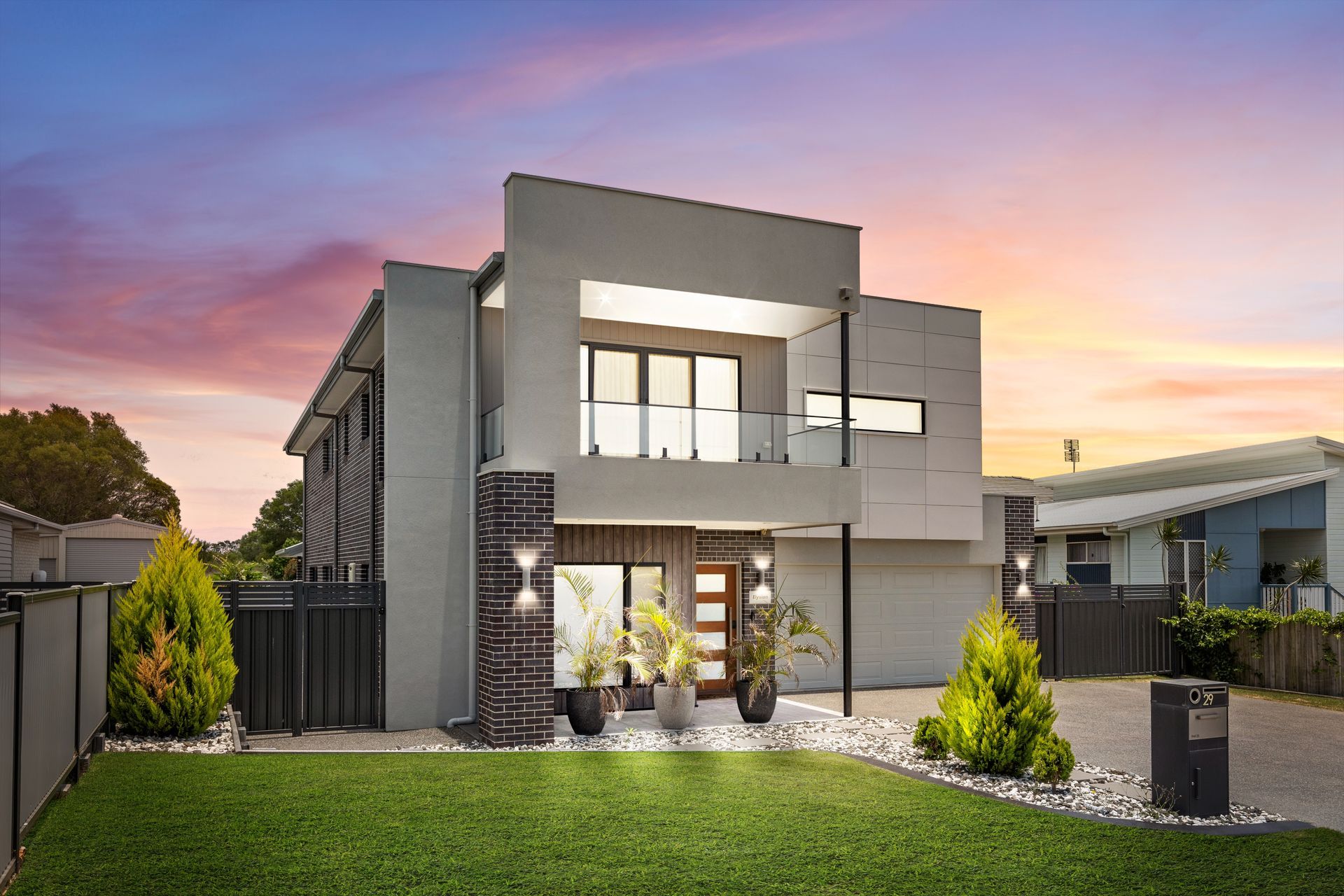 A Modern House With A Large Garage And A Balcony — Jack West Photography In Kawungan, QLD
