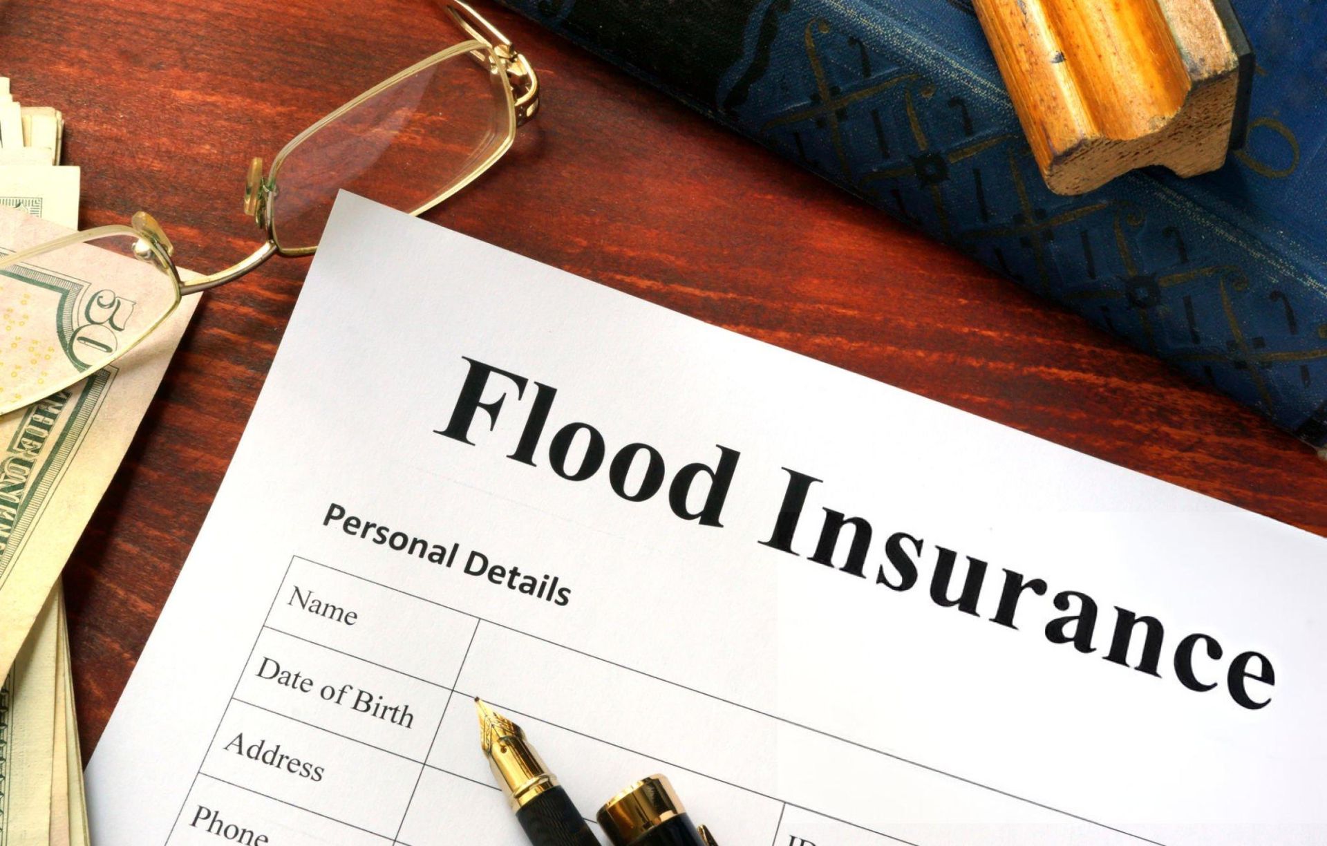 A flood insurance form is on a wooden table