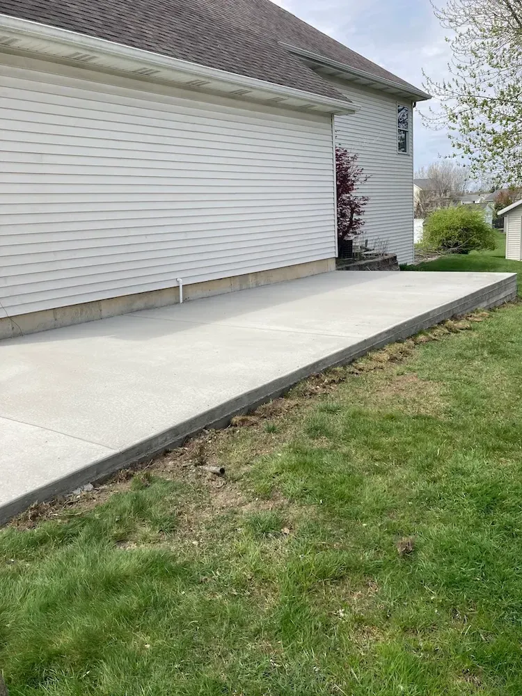 A white house with a concrete driveway in front of it.