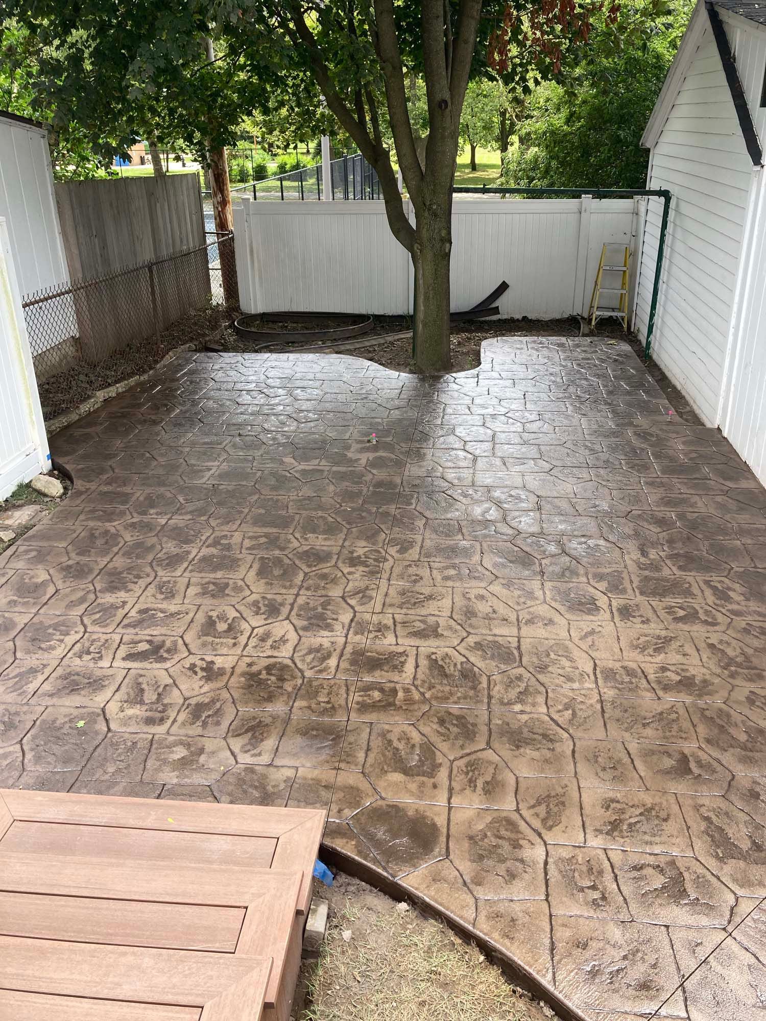 A group of men are working on a concrete floor in a yard.