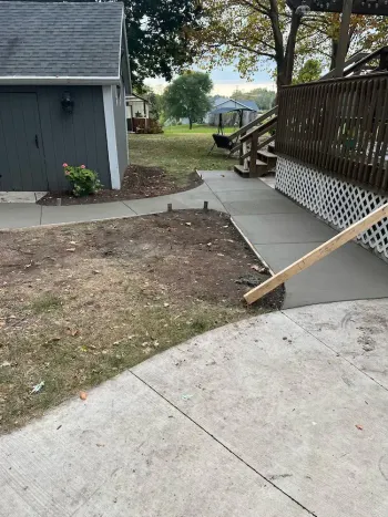 A concrete walkway is being built in front of a house.