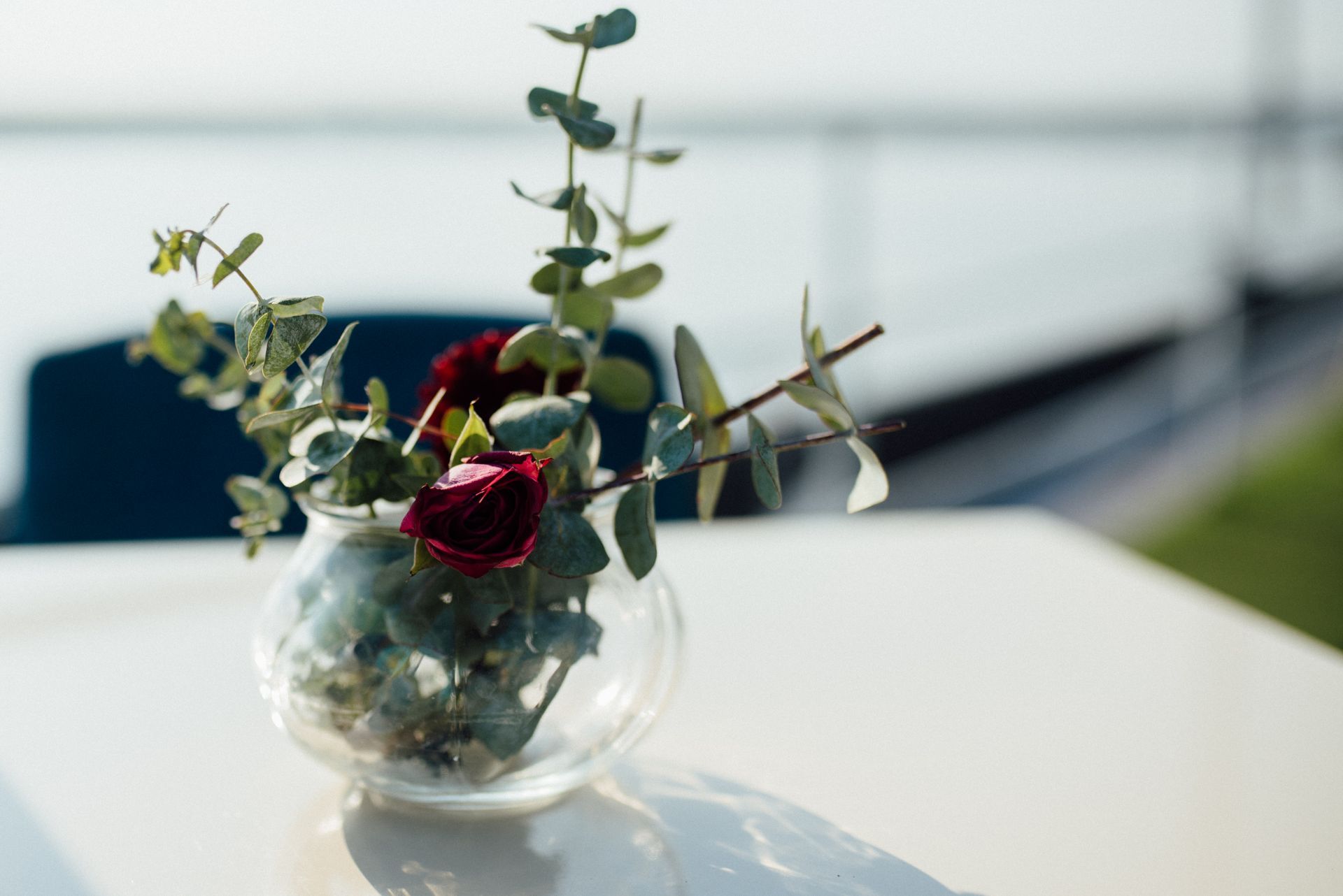 A delicate vase with small flowers placed on a wedding reception table.