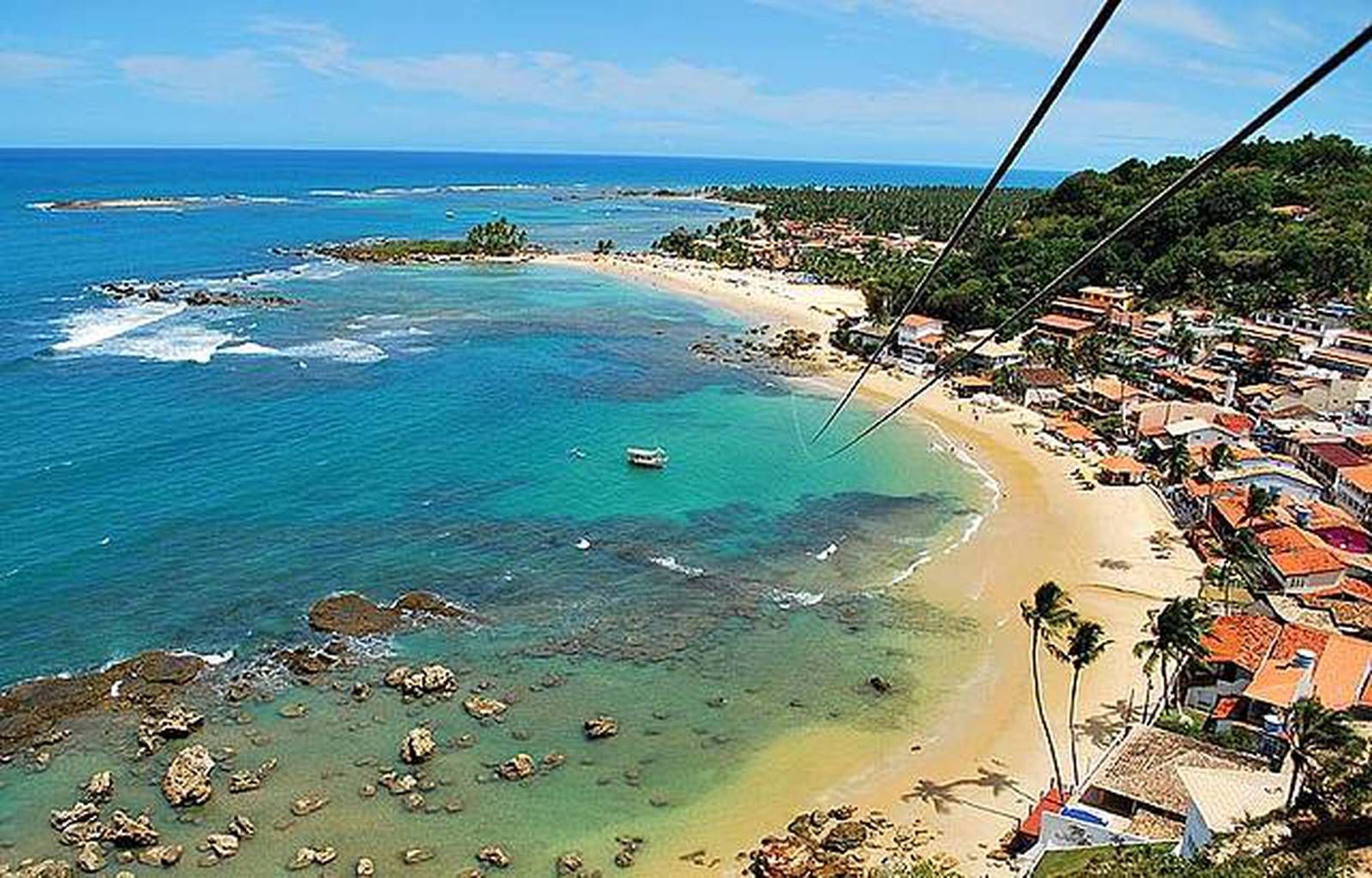 Uma vista aérea de uma praia com um barco na água