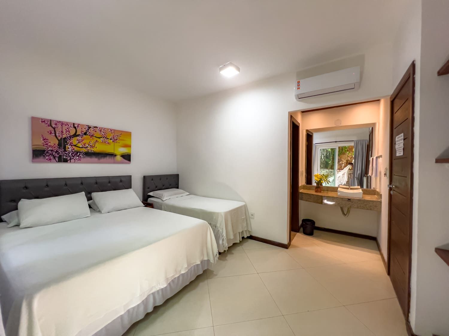 Uma cadeira de vime está sobre um deck de madeira ao lado de uma piscina com vista para o oceano.