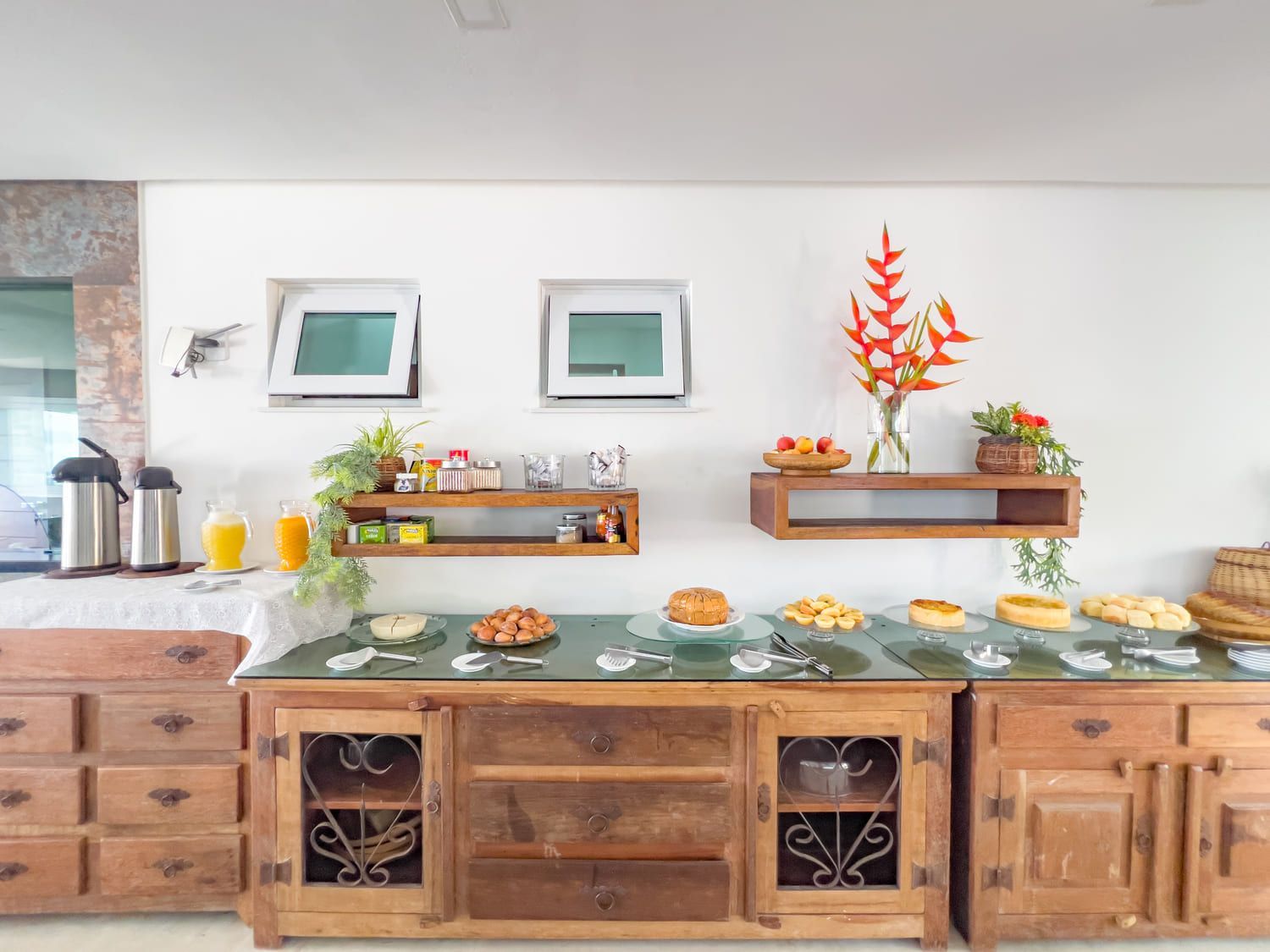 Uma mesa com uma tigela de frutas e duas jarras de suco de laranja.