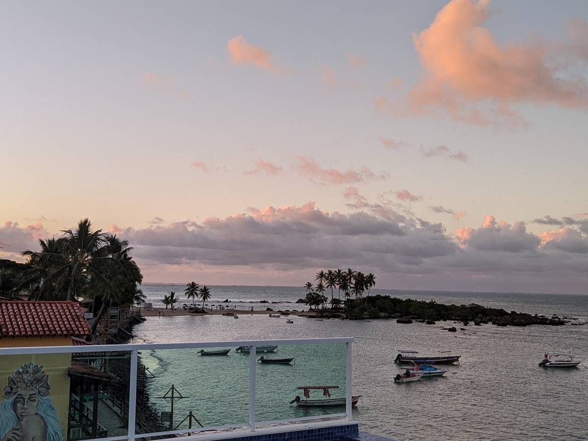 Um pôr do sol sobre um corpo d'água com barcos nele