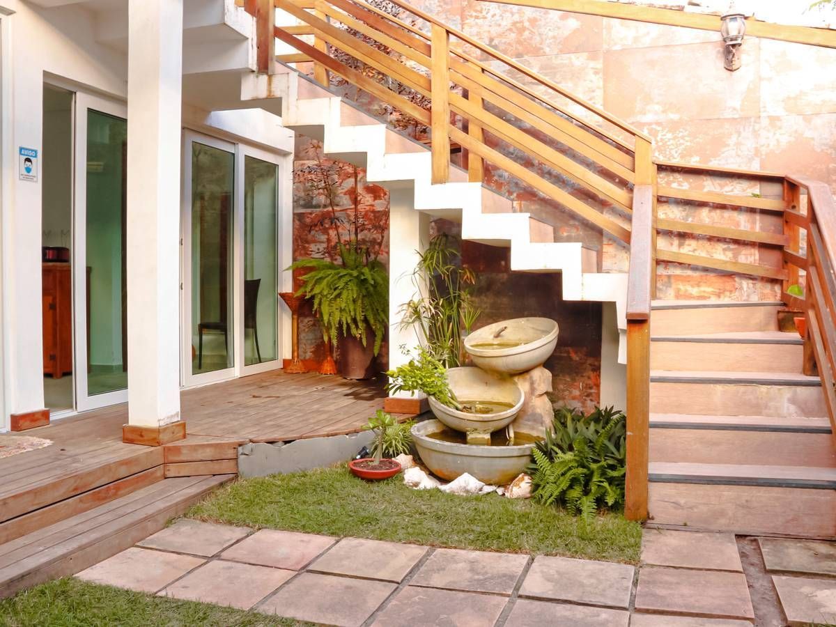 Uma casa com escadas e uma fonte na frente