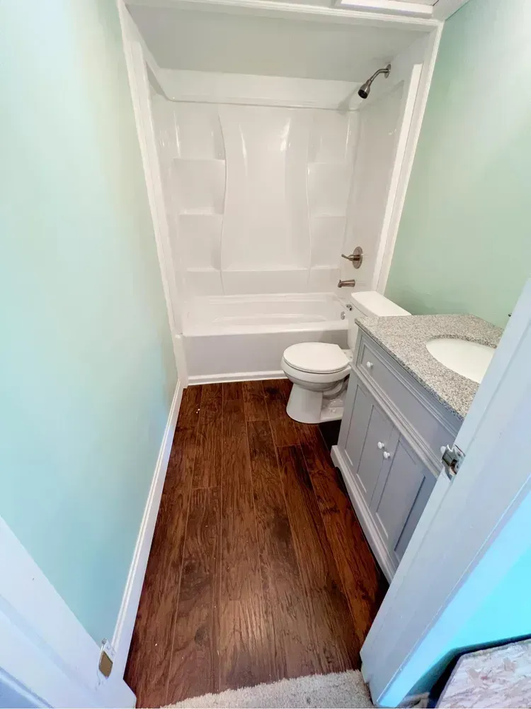 A bathroom with a toilet , sink and bathtub.