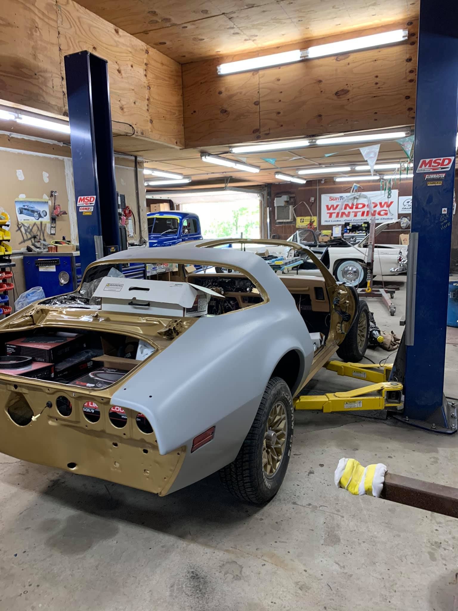A car is sitting on a lift in a garage.
