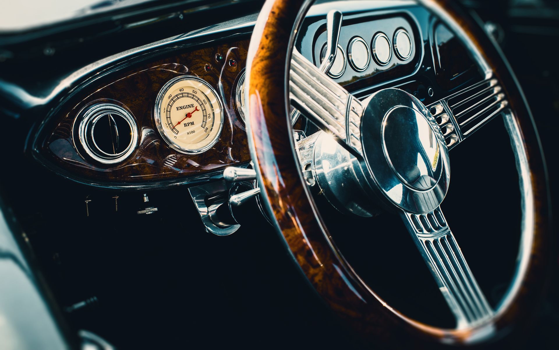Interior dashboard and steering wheel of a beautifully restored classic car.