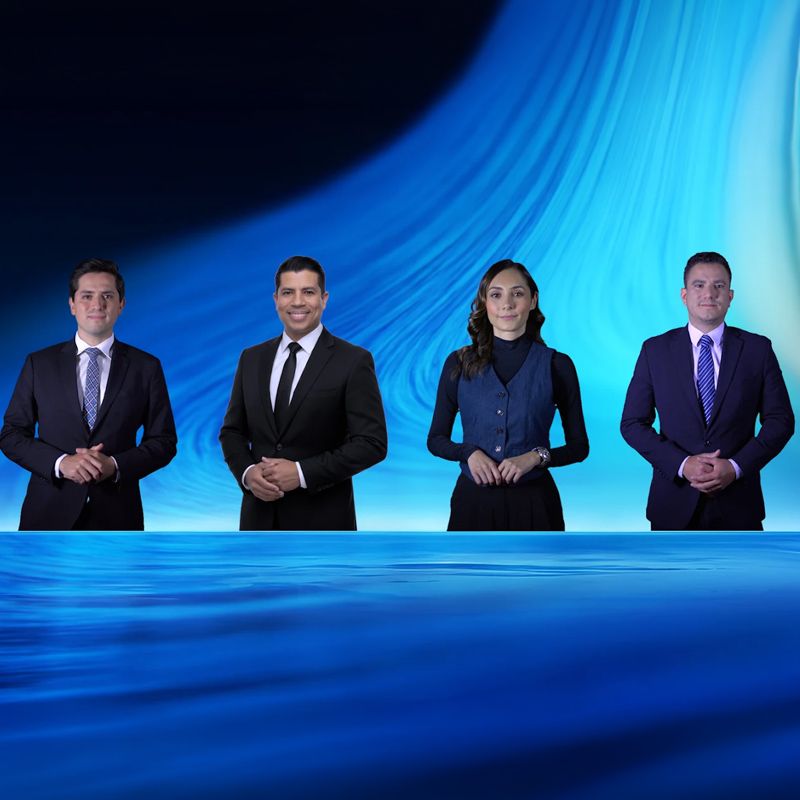 A group of people are posing for a picture in a news studio.