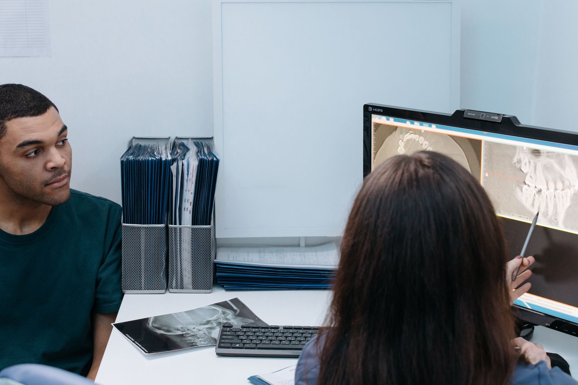 A Man And A Woman Are Looking At A Computer Screen — Dr Patrick Meaney In Moss Vale, NSW