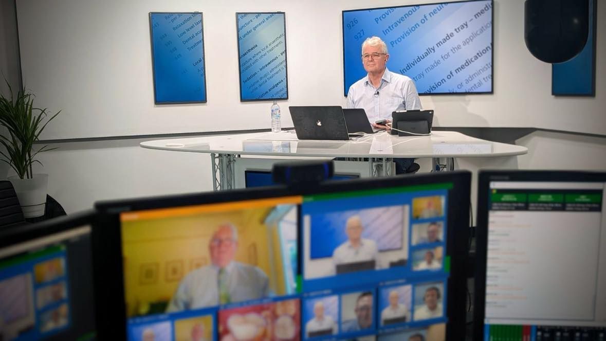 A Man Is Sitting At A Table Using A Laptop Computer — Dr Patrick Meaney In Moss Vale, NSW