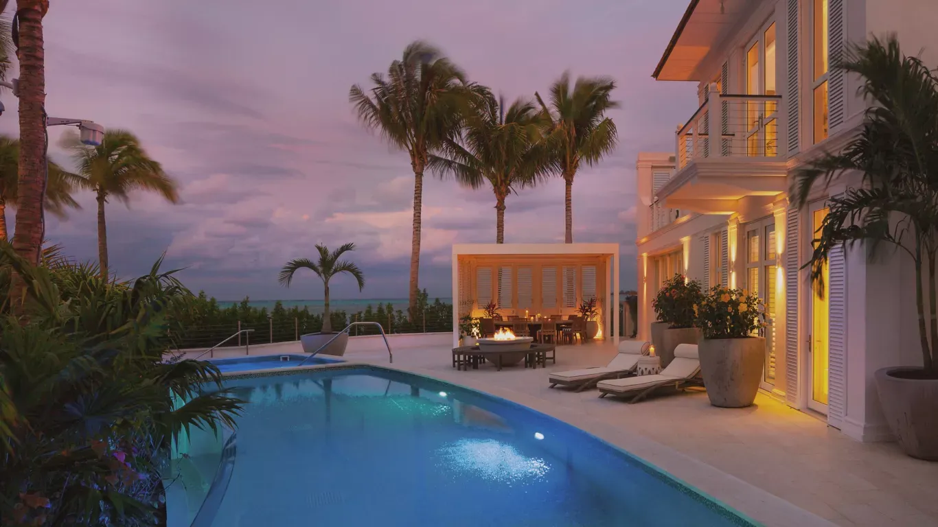 A large house with a swimming pool in front of it