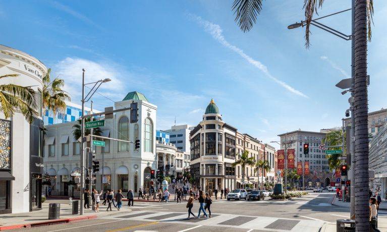 A group of people are crossing a street in a city.