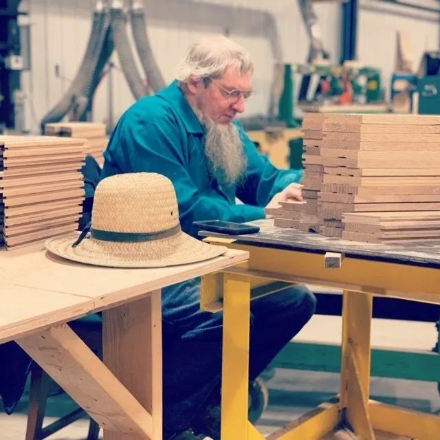 Amish artisan checking parquet pieces