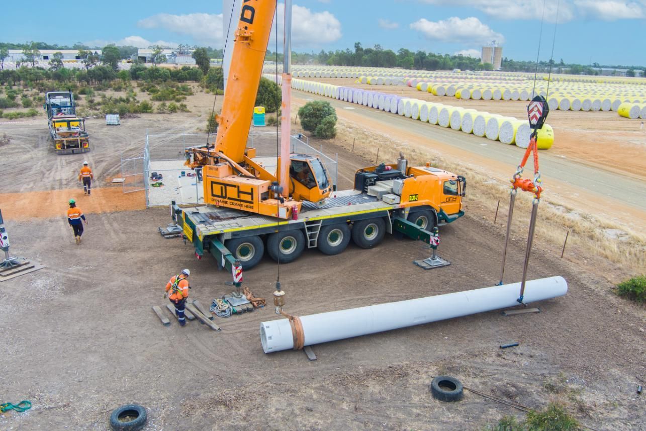 An Aerial View Of A Crane Lifting A Large Pipe On A Construction Site — Dynamic Crane Hire In Biloela, QLD