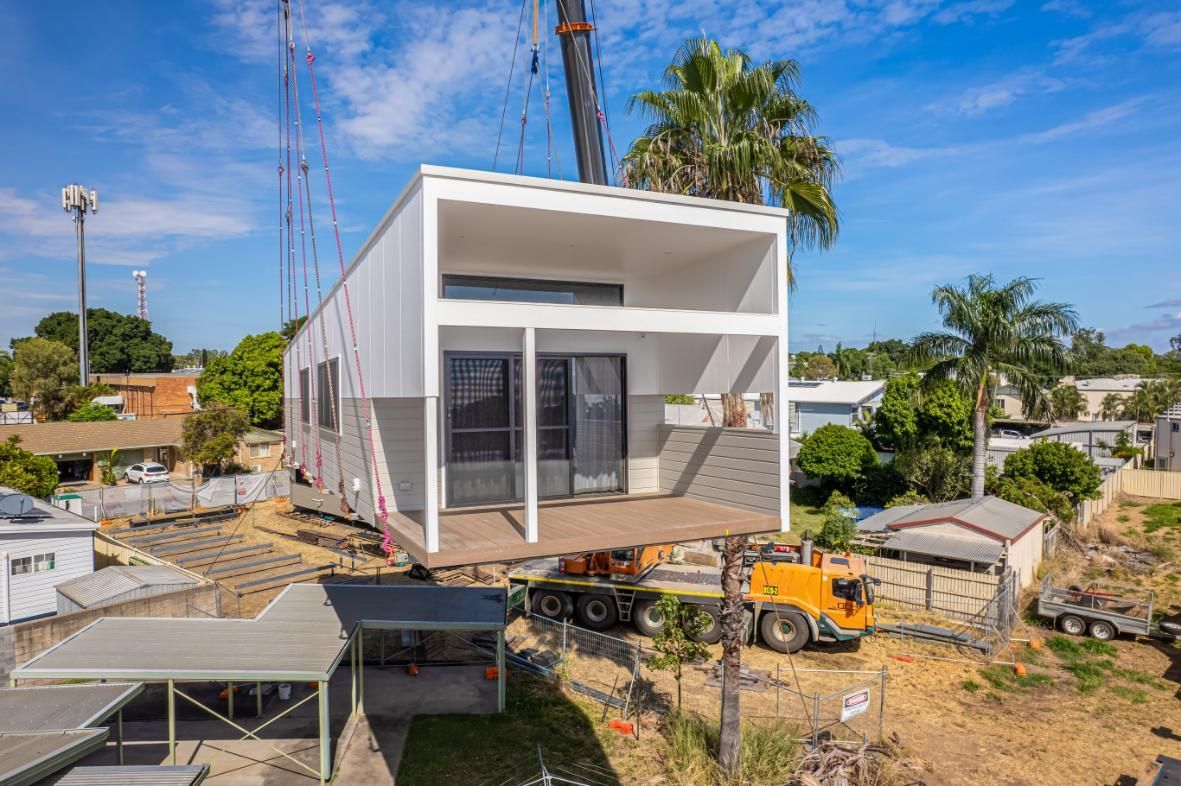 A Small House Is Being Lifted Into Place By A Crane — Dynamic Crane Hire In Emerald, QLD