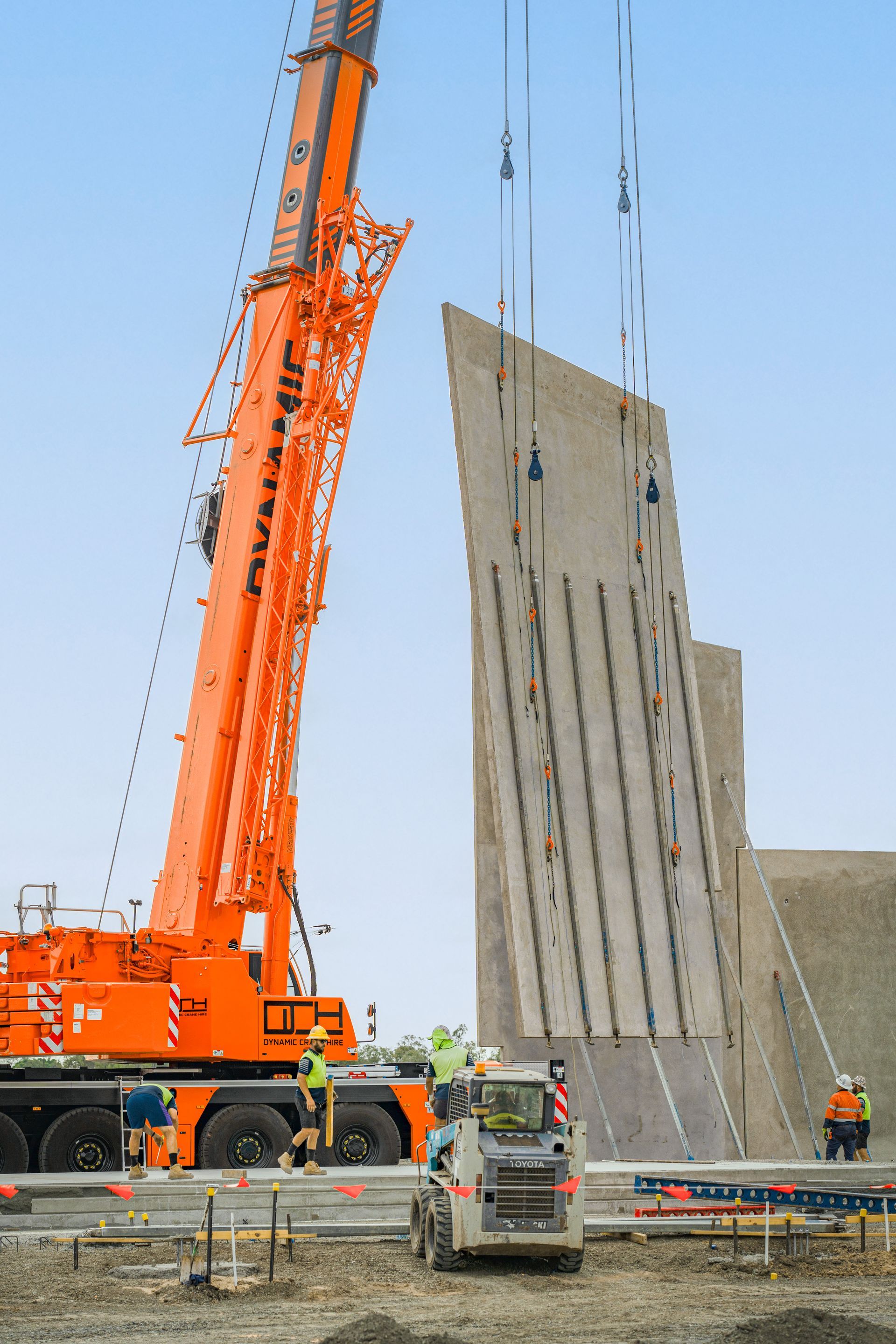 A Large Orange Crane Is Lifting A Large Piece Of Concrete — Dynamic Crane Hire In Emerald, QLD