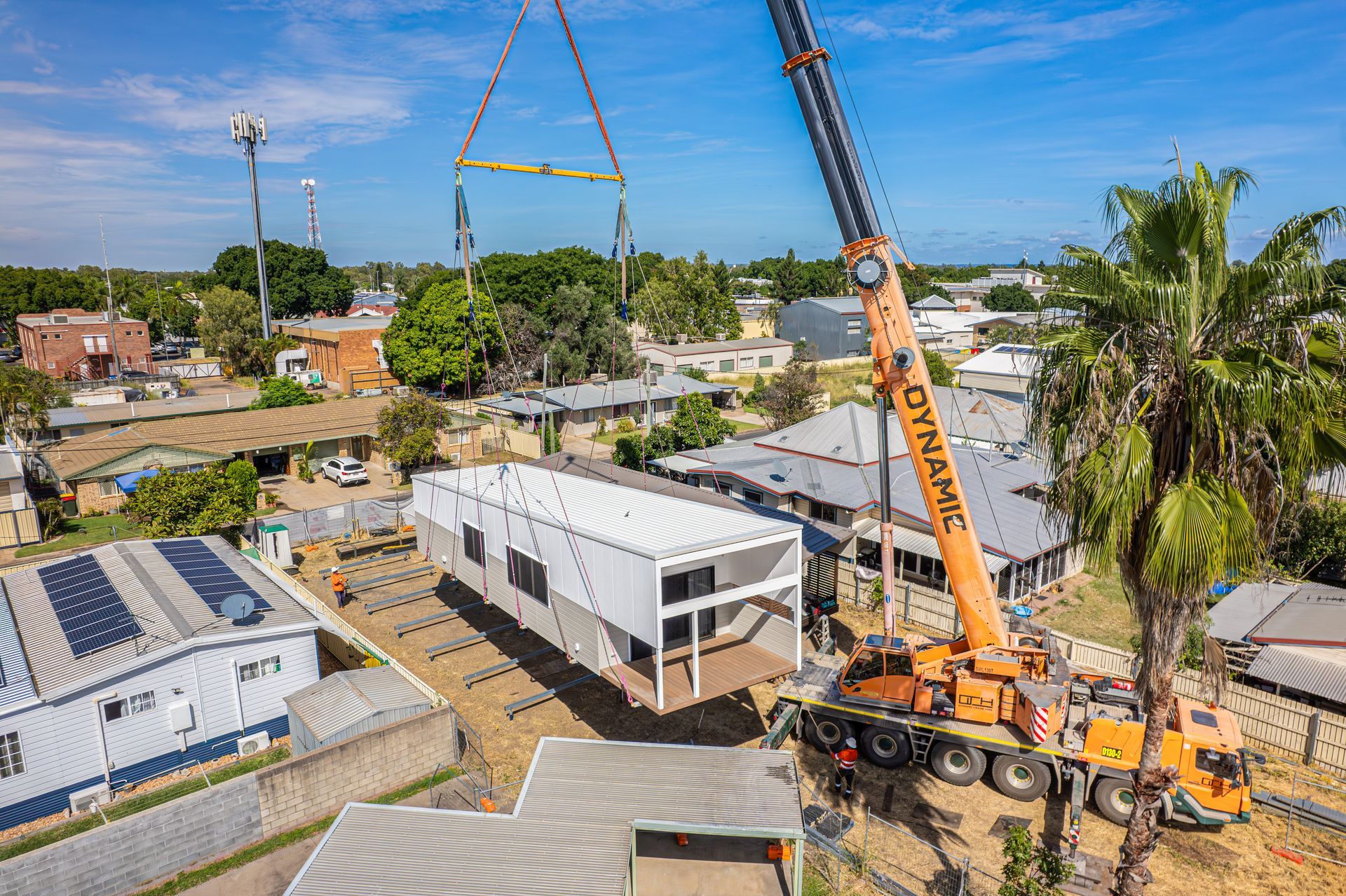 An Aerial View Of A Crane Lifting A House In A Residential Area — Dynamic Crane Hire In Emerald, QLD