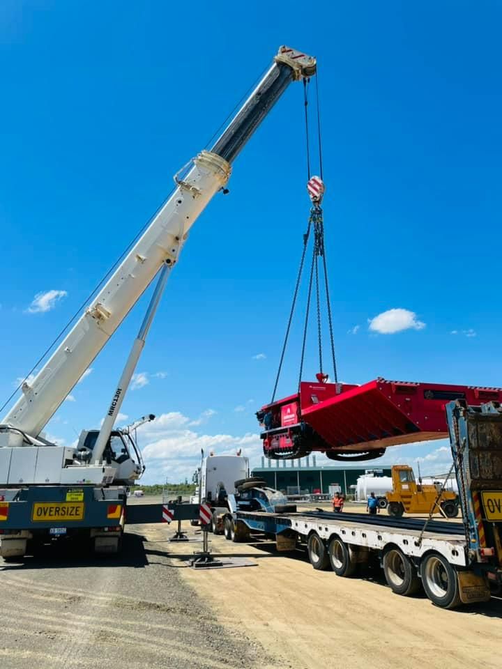 A Large Crane Is Lifting A Red Vehicle From A Trailer — Dynamic Crane Hire In Emerald, QLD