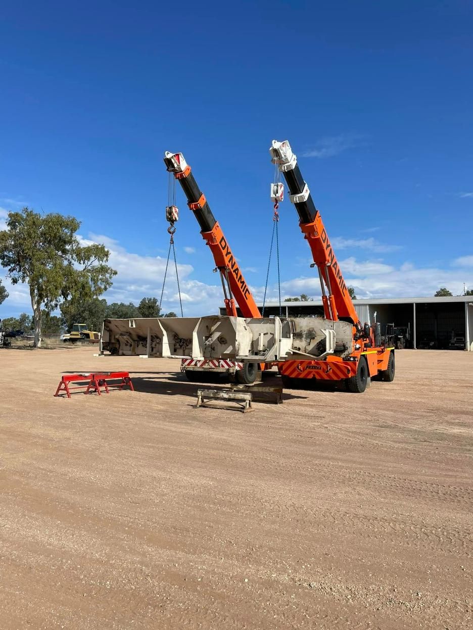 A Couple Of Cranes Are Sitting In A Dirt Field — Dynamic Crane Hire In Middlemount, QLD
