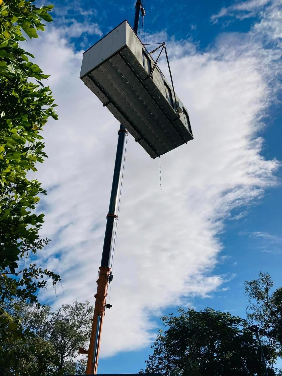 A Large Box Is Being Lifted Into The Air By A Crane — Dynamic Crane Hire In Emerald, QLD