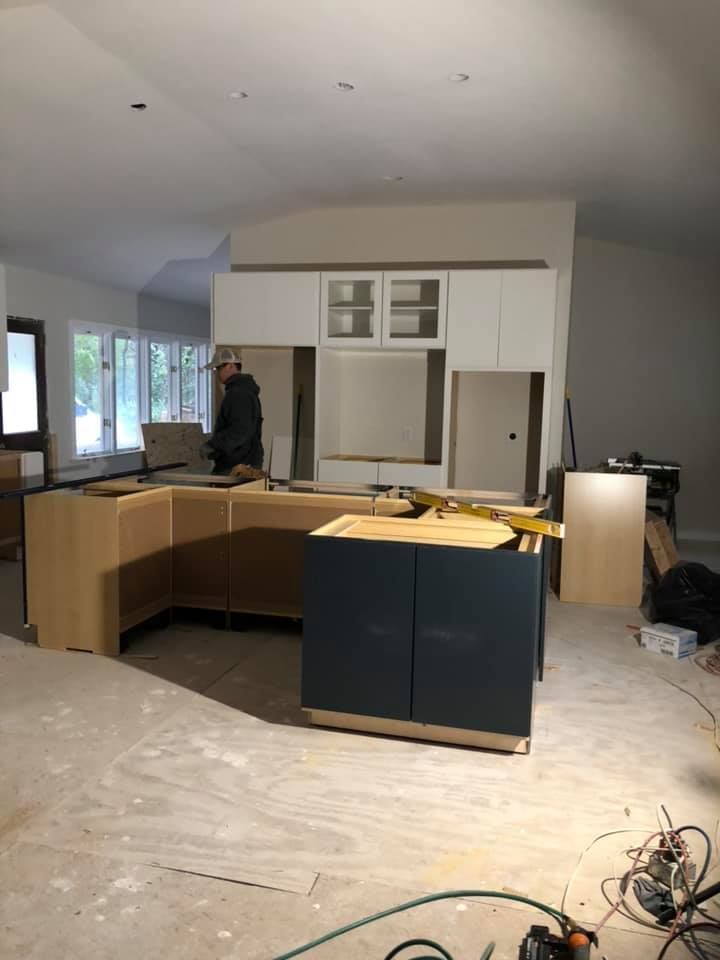 A man is working on a kitchen in a house under construction.