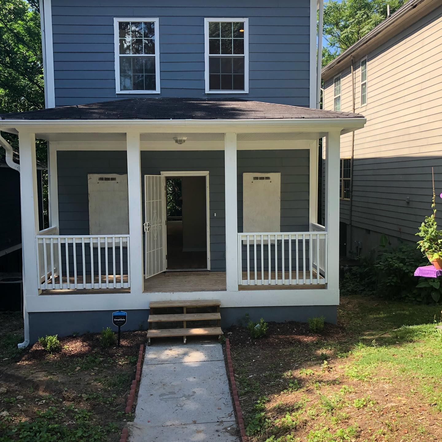 A blue house with a white porch and stairs