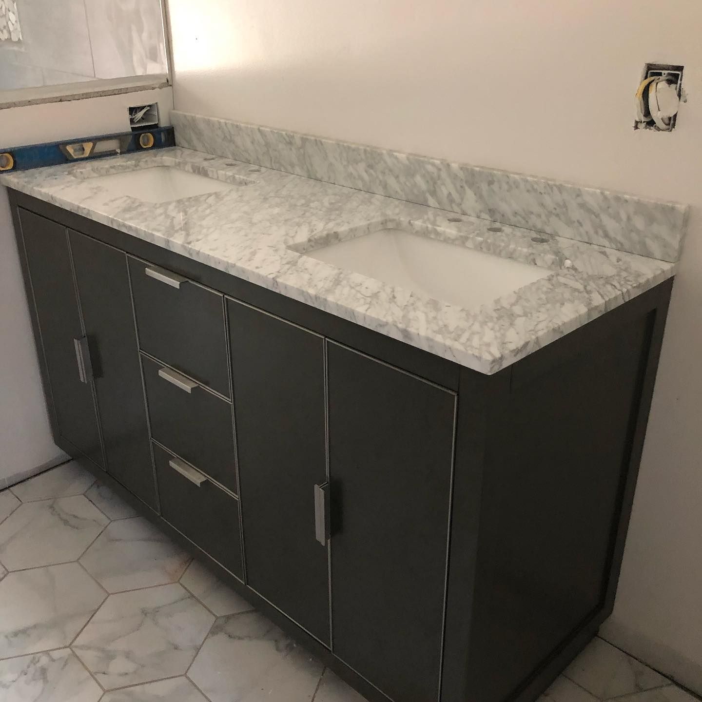 A bathroom vanity with two sinks and a marble counter top.