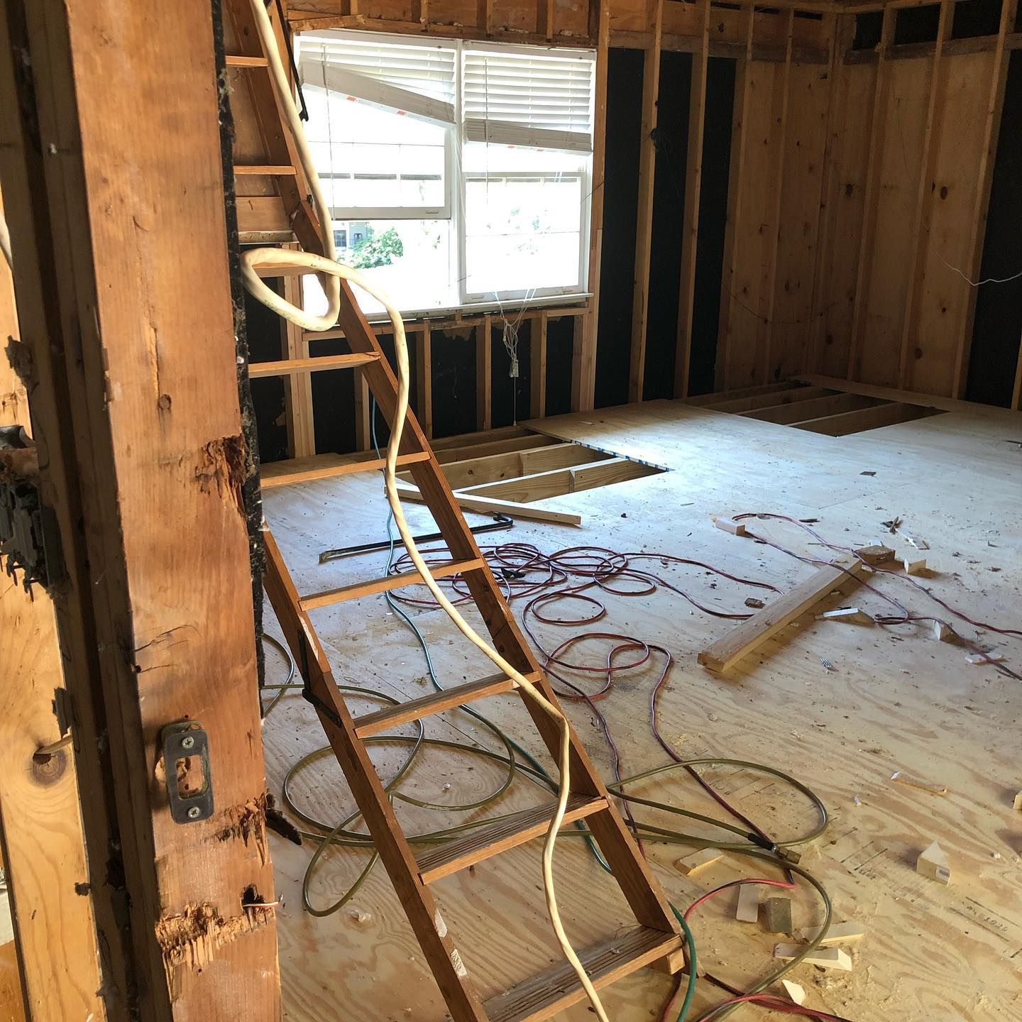 A wooden ladder is leaning against a wall in a room under construction