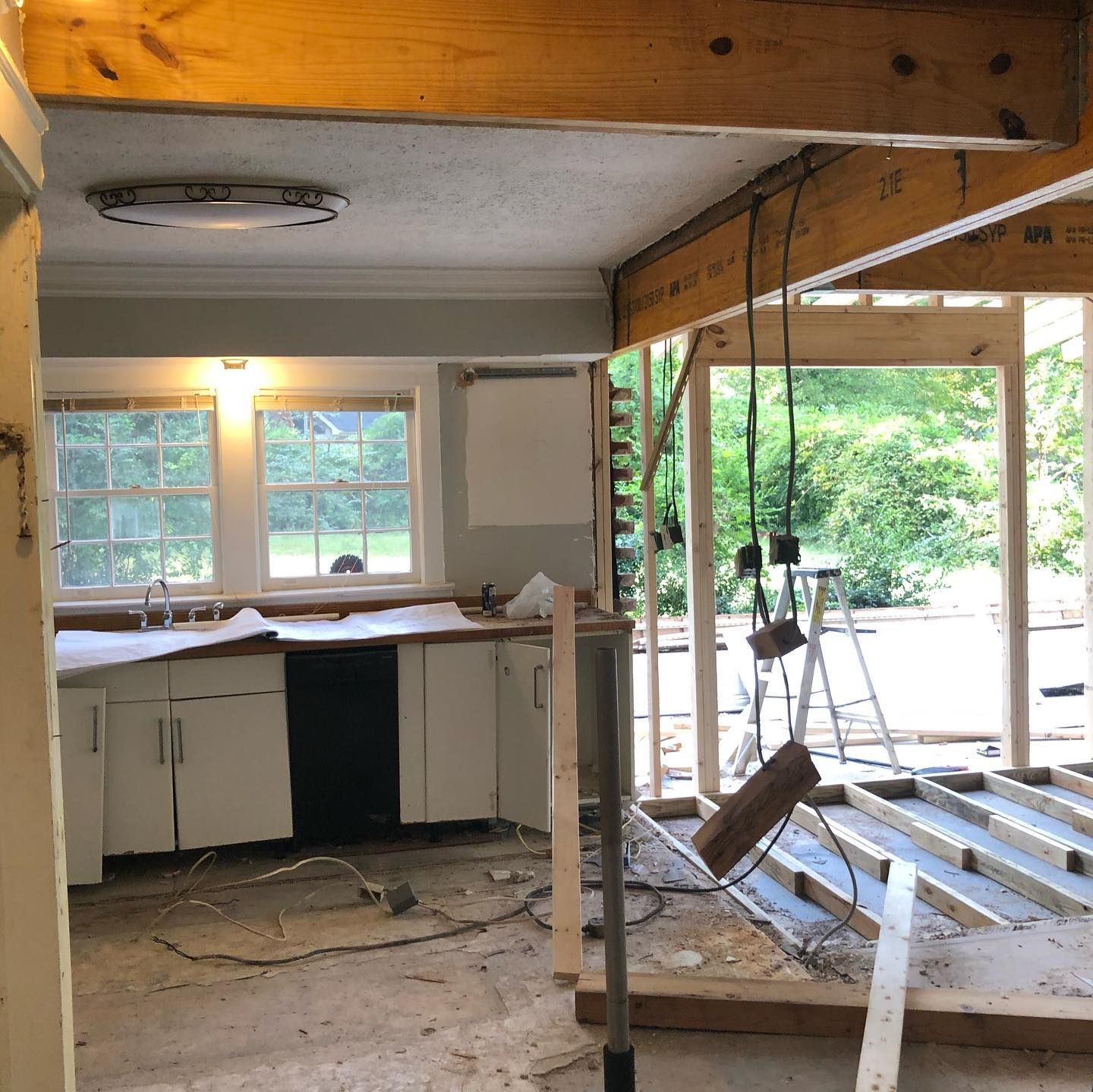 A kitchen under construction with a wooden beam hanging from the ceiling