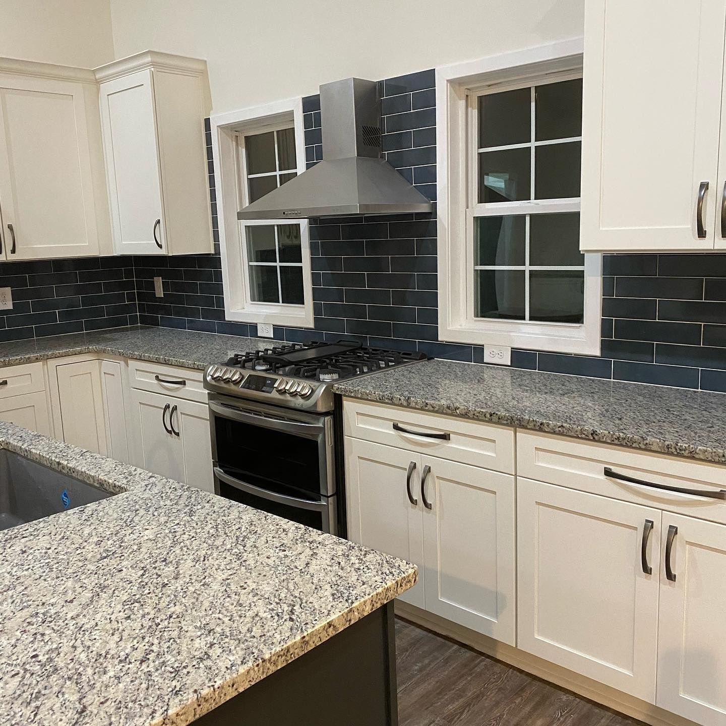A kitchen with white cabinets and granite counter tops